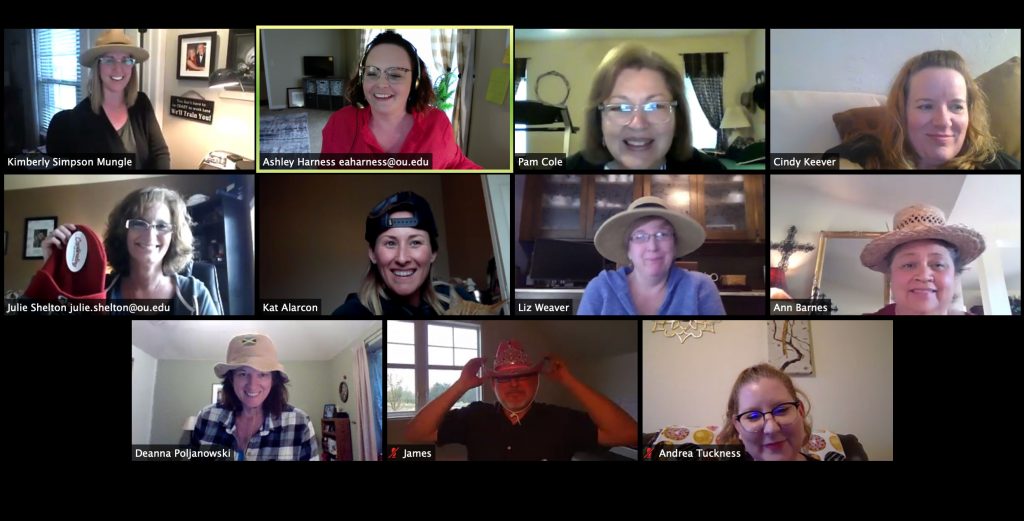 Zoom session with multiple people, some wearing hats.